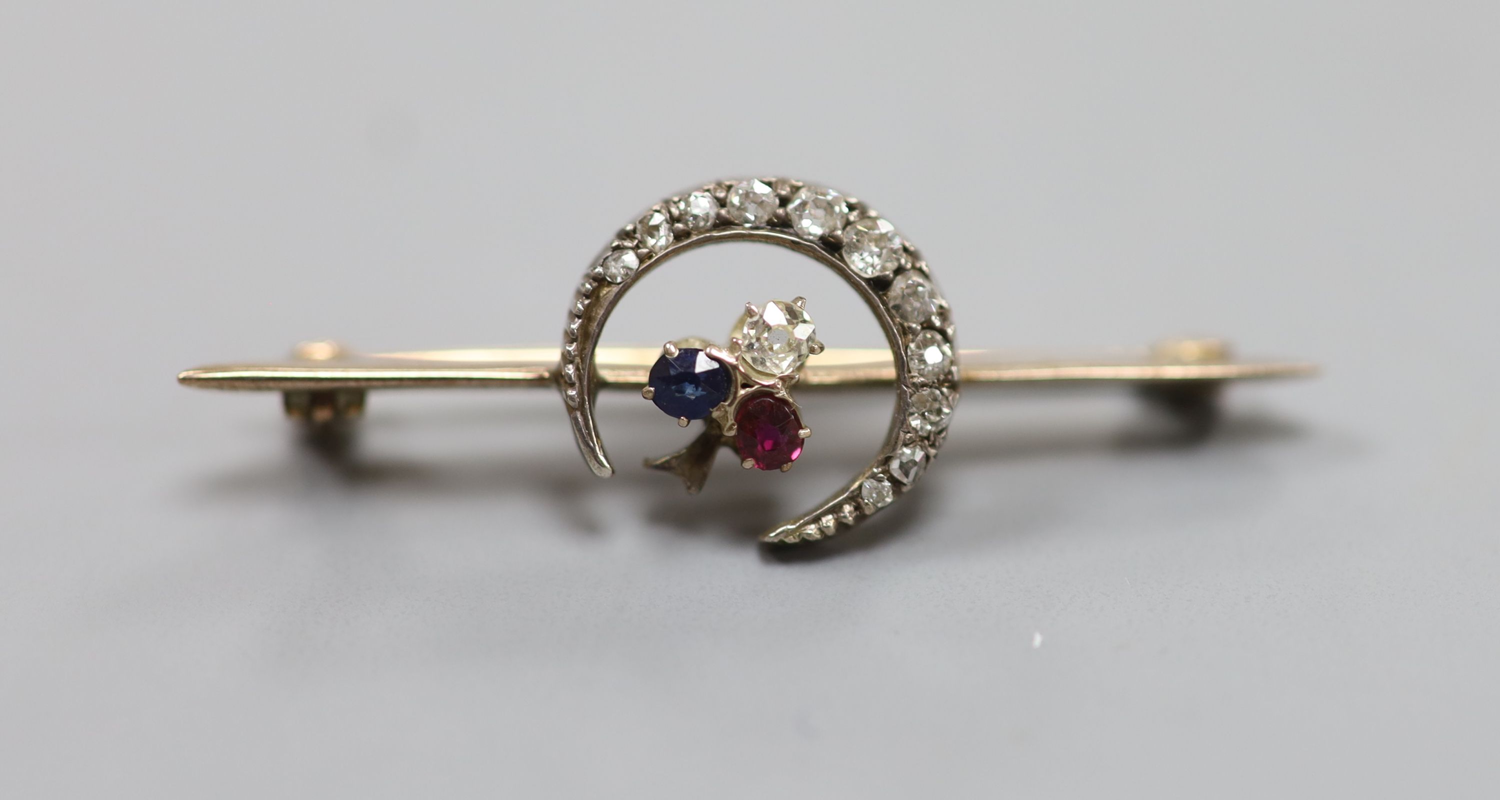 A late Victorian yellow metal, ruby and diamond set crescent and clover bar brooch